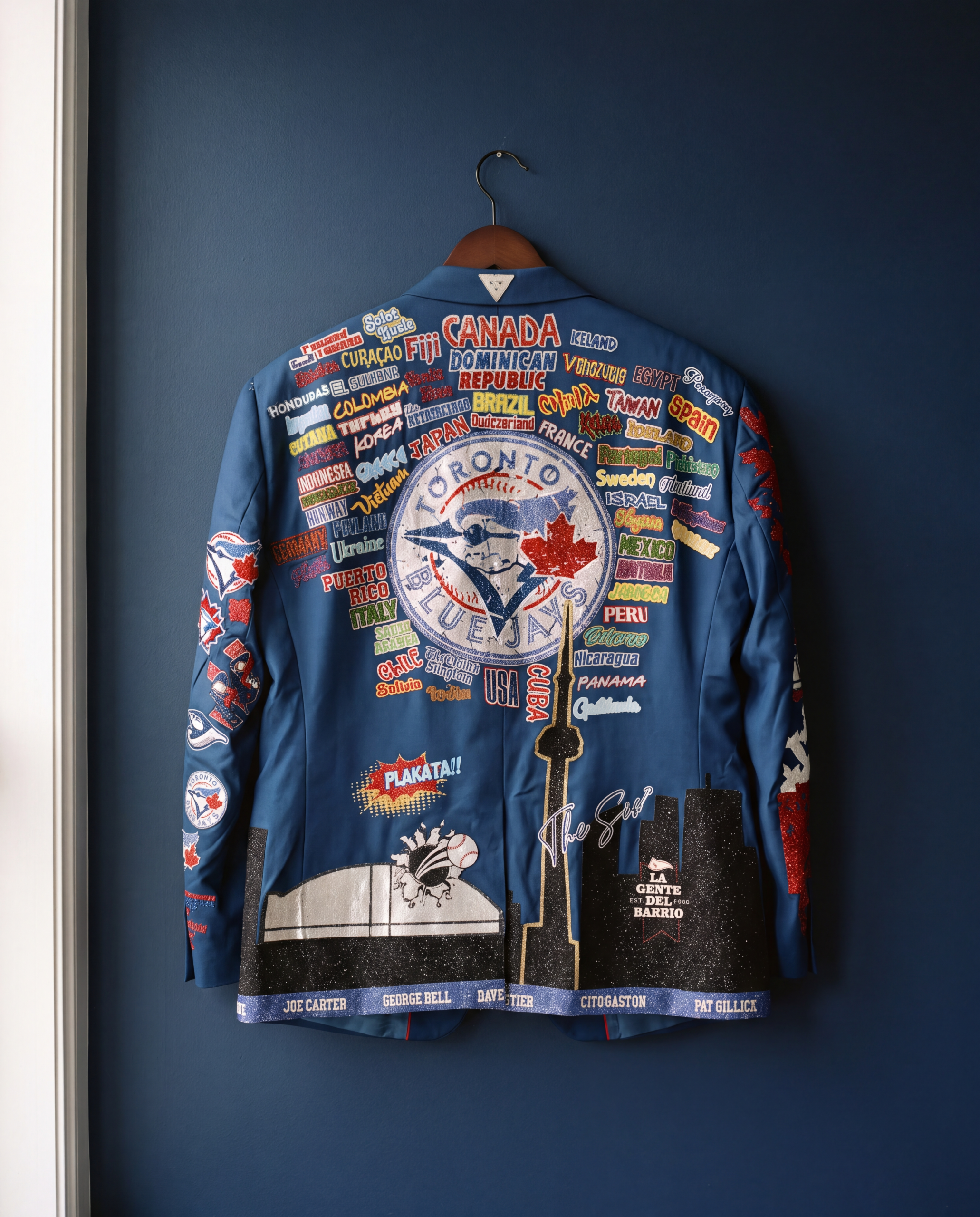 The back of the hand-beaded blazer hanging against a deep navy wall
